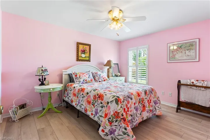 Bedroom featuring baseboards, wood finished floors, and ceiling fan