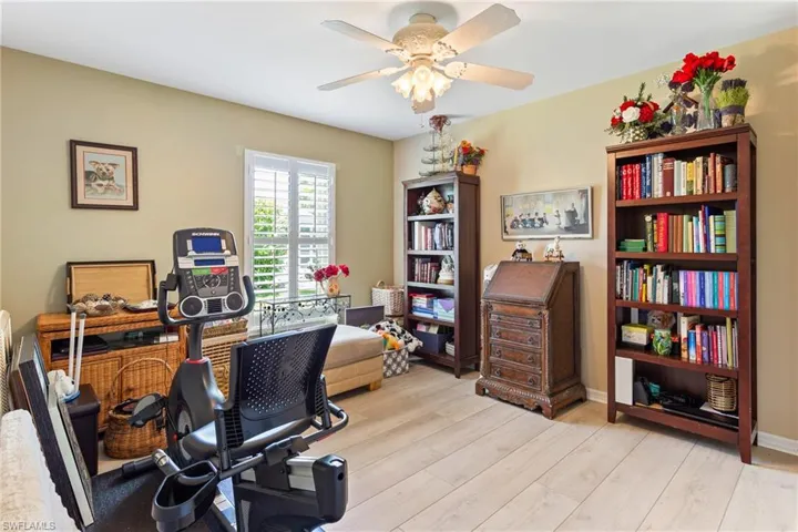 Office with light wood-style flooring and ceiling fan