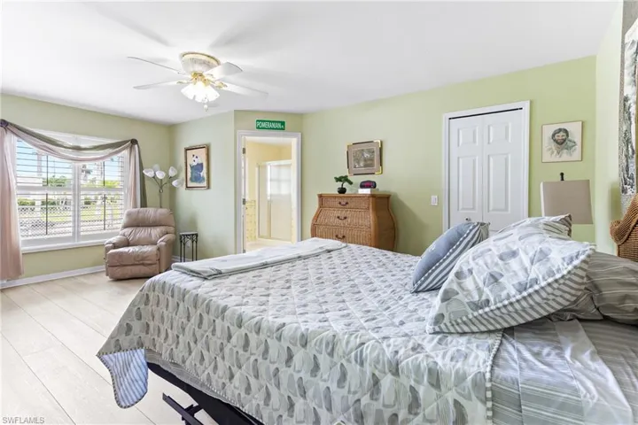 Bedroom featuring wood finished floors, a ceiling fan, a closet, baseboards, and connected bathroom