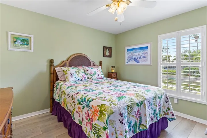 Bedroom featuring multiple windows, light wood-style flooring, and baseboards