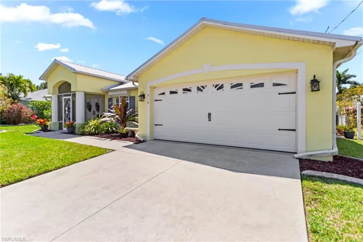 Ranch-style house featuring stucco siding, driveway, a front yard, and an attached garage