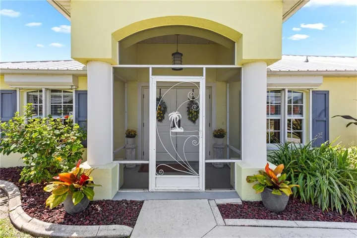 View of exterior entry featuring metal roof and stucco siding