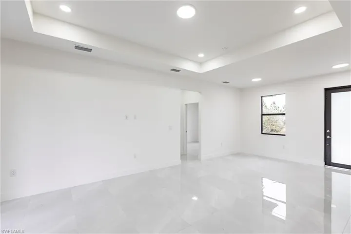 Unfurnished room featuring a tray ceiling, baseboards, and recessed lighting