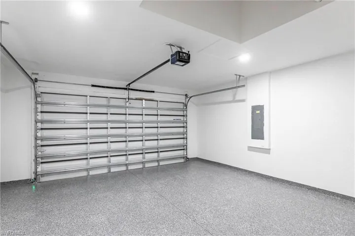 Garage featuring electric panel and a garage door opener