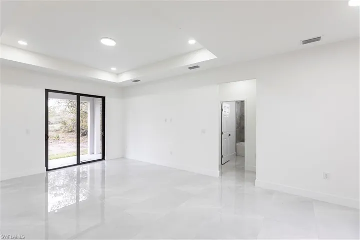 Empty room featuring recessed lighting, a raised ceiling, visible vents, and baseboards