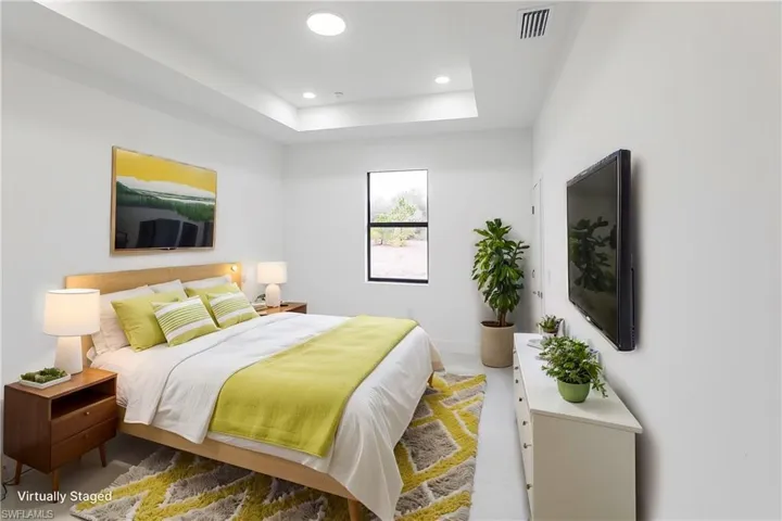 Bedroom featuring recessed lighting, a raised ceiling, visible vents, and baseboards