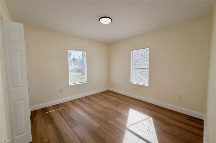 Unfurnished room with healthy amount of natural light and wood finished floors