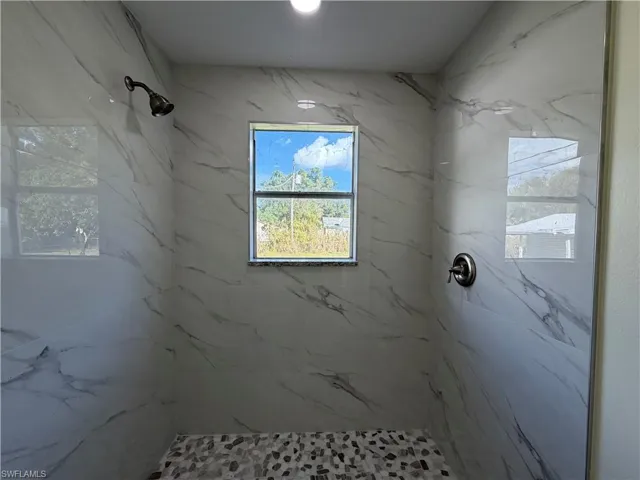 Bathroom with a marble finish shower