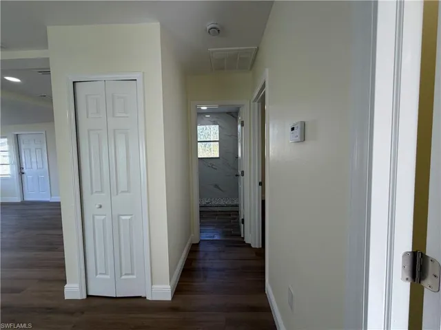 Hallway featuring baseboards and dark wood-type flooring