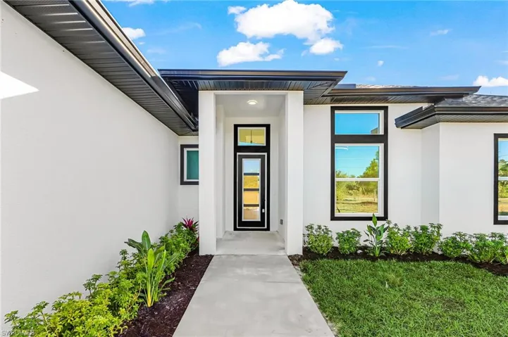 Doorway to property featuring stucco siding