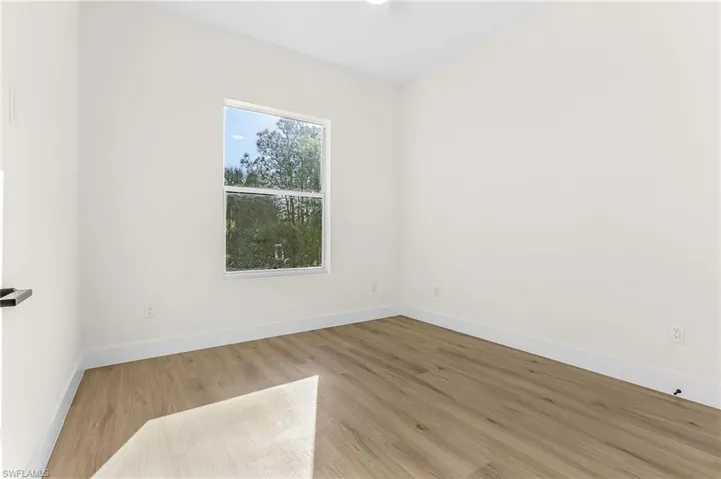 Spare room featuring wood finished floors and baseboards