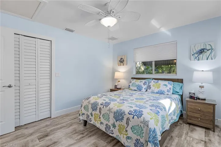 Bedroom with a closet, light hardwood / wood-style flooring, and ceiling fan