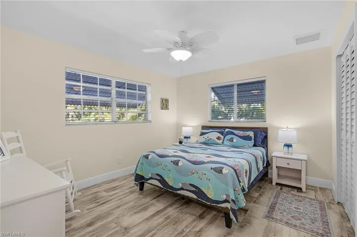 Bedroom with ceiling fan, light hardwood / wood-style floors, and a closet