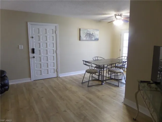 Dining area with ceiling fan, a textured ceiling, and light hardwood / wood-style floors