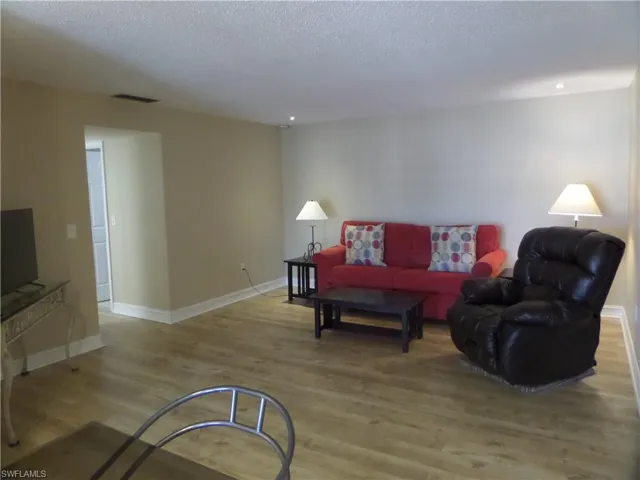 Living room featuring a textured ceiling and light hardwood / wood-style flooring
