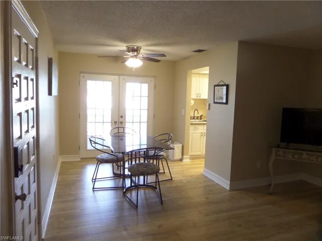 Dining space featuring sink, hardwood / wood-style flooring, ceiling fan, a textured ceiling, and french doors
