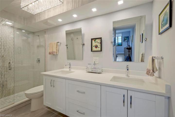 En suite bathroom with walk-in shower and dual sinks.