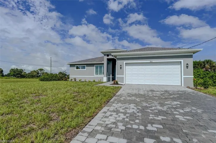 Ranch-style home featuring a garage and a front lawn