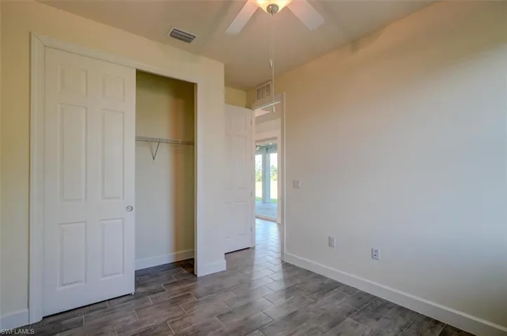 Unfurnished bedroom featuring a closet, ceiling fan, and dark hardwood / wood-style floors