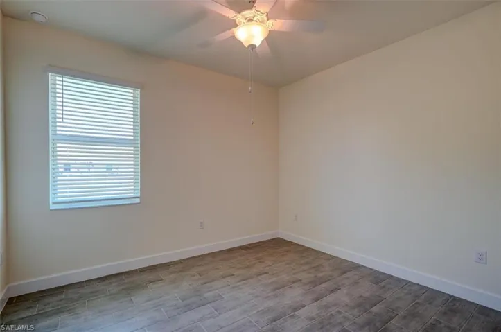Unfurnished room with hardwood / wood-style flooring and ceiling fan