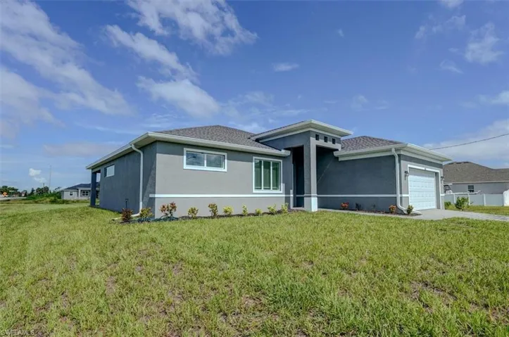 View of front of house featuring a garage and a front yard