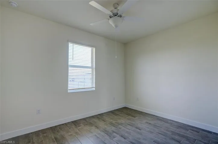 Empty room featuring hardwood / wood-style flooring and ceiling fan