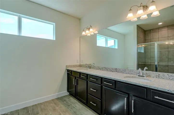 Bathroom featuring double vanity and wood-type flooring