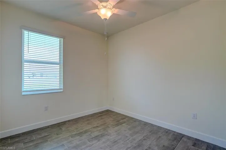 Unfurnished room featuring ceiling fan and hardwood / wood-style flooring