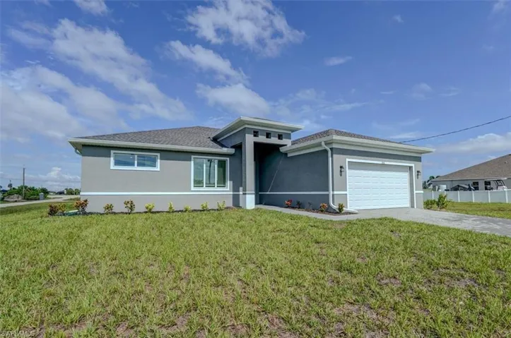 View of front facade with a garage and a front lawn