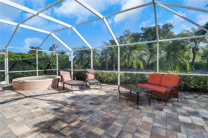View of patio / terrace featuring an in ground hot tub, outdoor lounge area, and glass enclosure