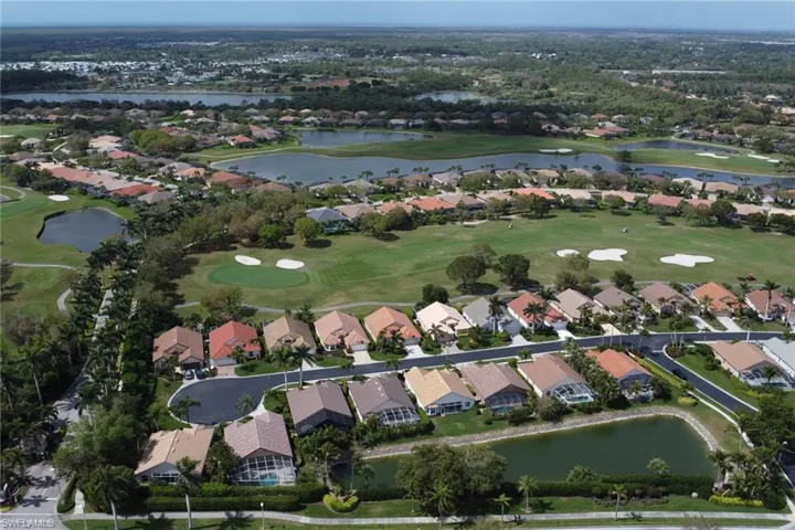 Drone / aerial view featuring view of golf course, a water view, and a residential view