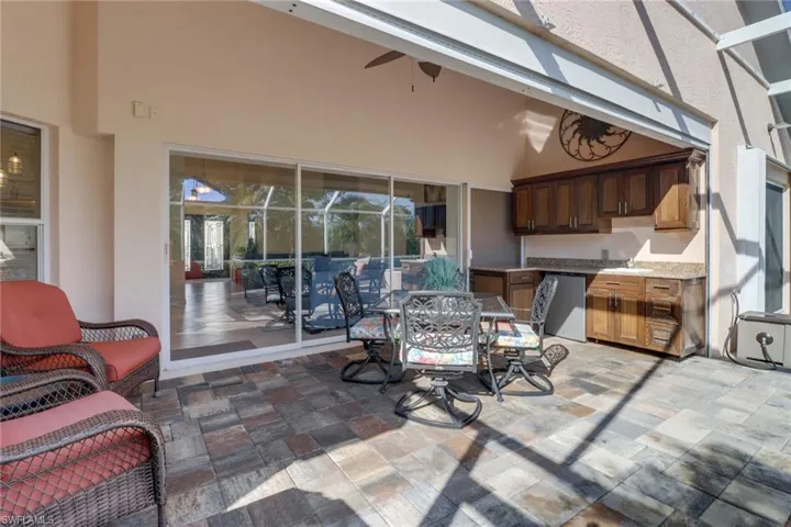 View of patio with ceiling fan and a lanai