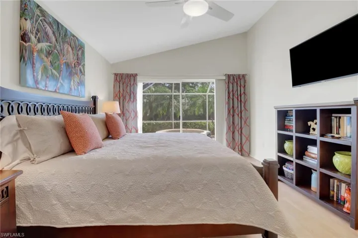 Bedroom with vaulted ceiling, access to outside, ceiling fan, and light hardwood / wood-style flooring