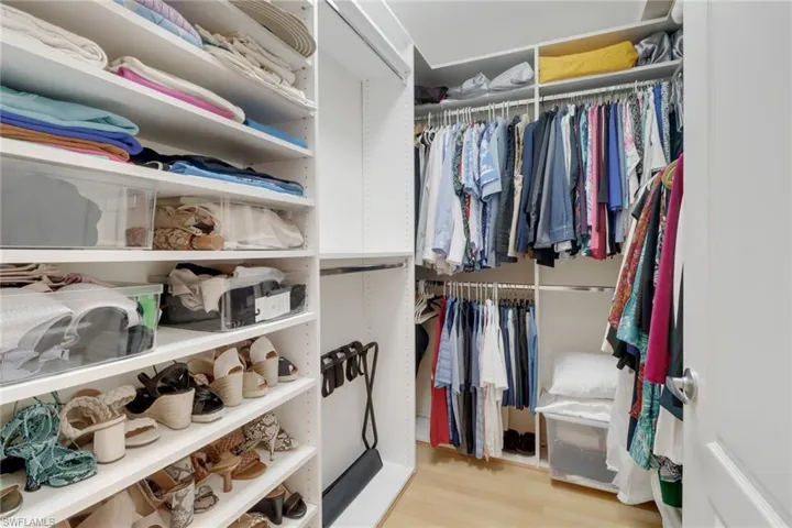 Spacious closet with light hardwood / wood-style flooring