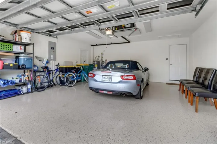 Garage featuring electric panel and a garage door opener