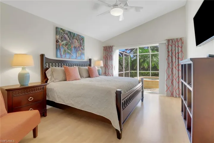 Bedroom featuring light hardwood / wood-style flooring, access to outside, ceiling fan, and vaulted ceiling