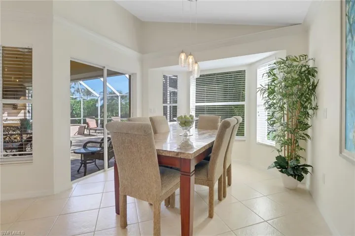 Tiled dining area with an inviting chandelier and vaulted ceiling