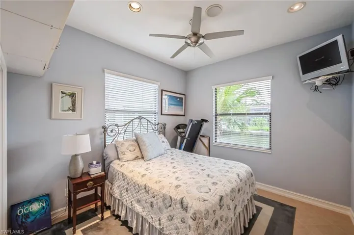 Tiled bedroom featuring ceiling fan