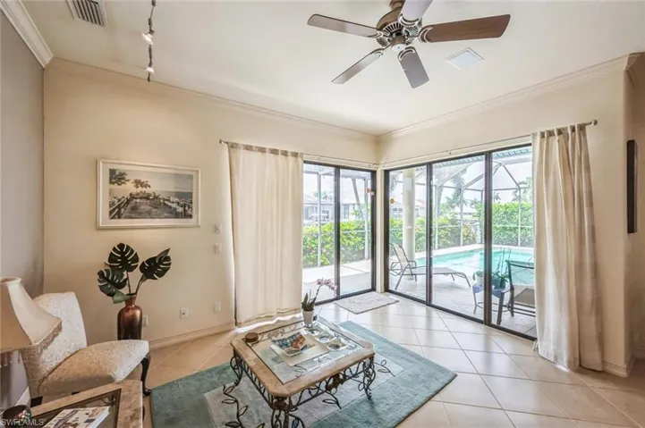 Tiled living room featuring ornamental molding, ceiling fan, and rail lighting