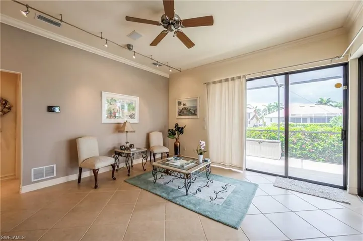 Sitting room featuring track lighting, light tile flooring, and crown molding