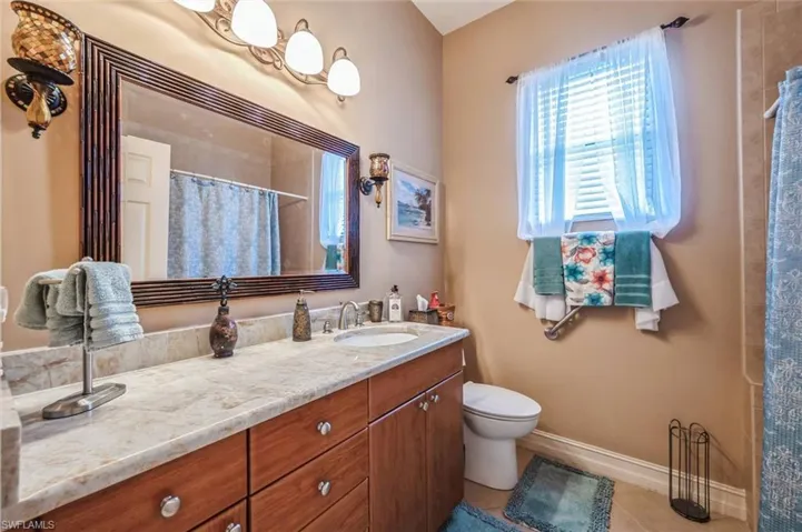 Bathroom featuring tile flooring, toilet, and oversized vanity