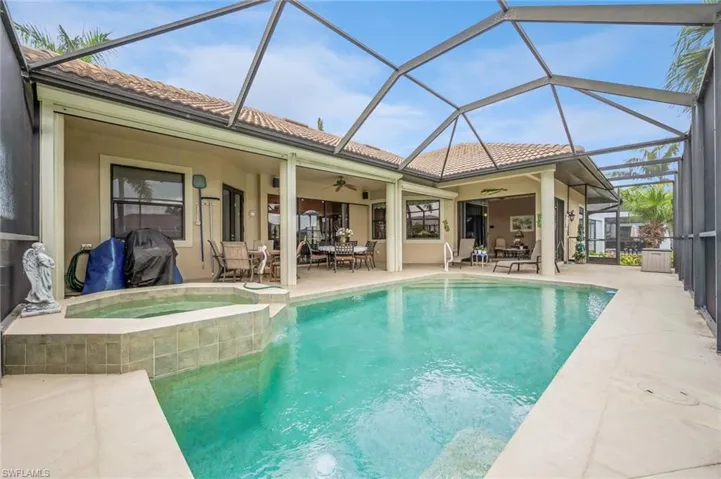View of pool featuring a patio, glass enclosure, an in ground hot tub, and ceiling fan