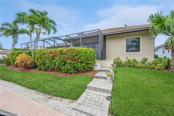 View of front of home featuring a lanai and a front lawn