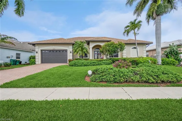 Mediterranean / spanish home with a front lawn and a garage