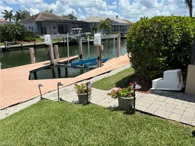 Dock area with a lawn and a water view