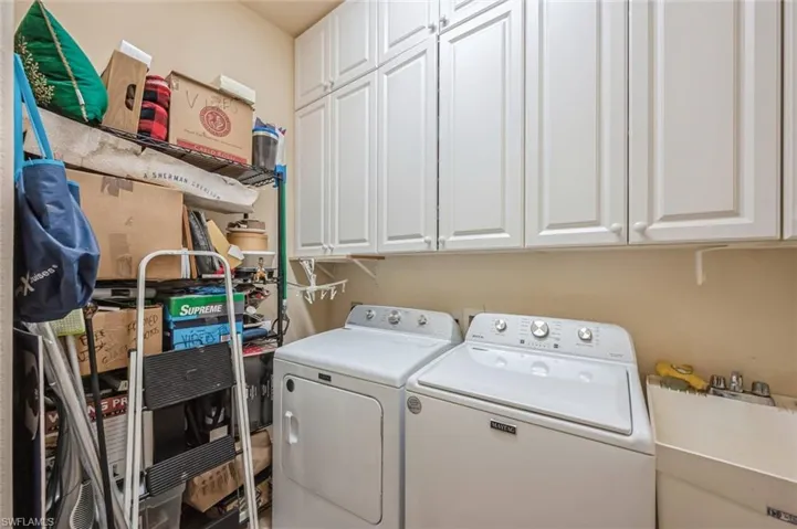 Laundry area featuring cabinets, sink, and washing machine and dryer