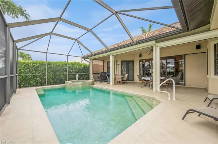 View of pool featuring a patio area, a lanai, and an in ground hot tub