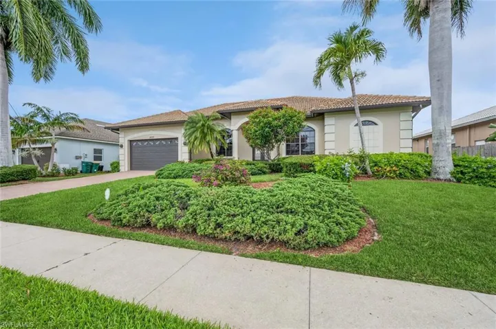 View of front of house with a garage and a front yard