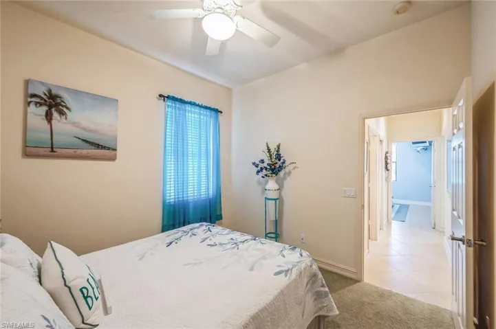 Carpeted bedroom featuring ceiling fan