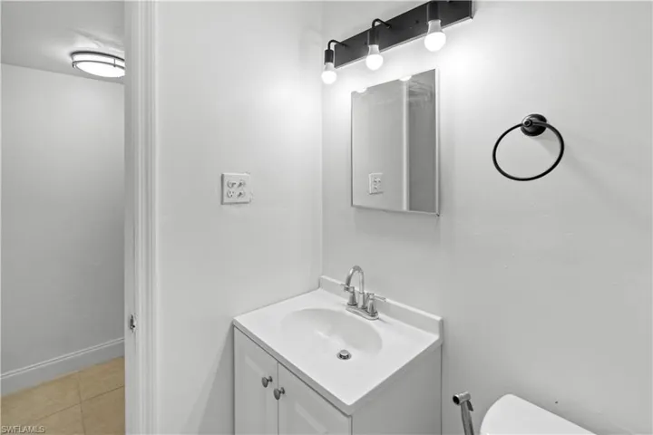 Half bathroom featuring vanity and light tile patterned floors